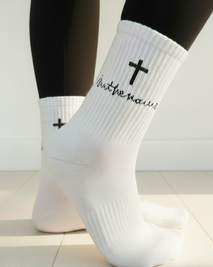 White socks with black crosses and text worn by a person on a light background